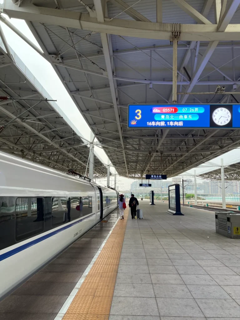Andén de una estación de tren de alta velocidad en China con panel de salidas