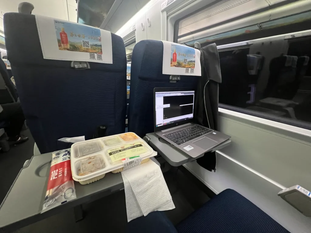 Portátil y cena en la mesa de un tren de alta velocidad en China durante un viaje de negocios
